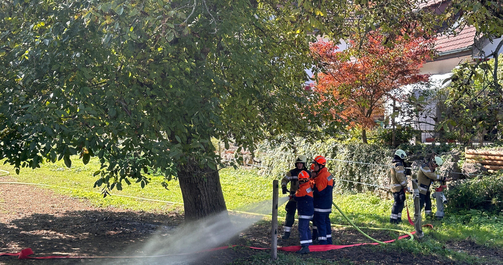 Die Jugendfeuerwehr hält mit einer Druckleitung die Rückseite der Scheune um einen Übergriff auf den Hühnerstall zu verhindern.